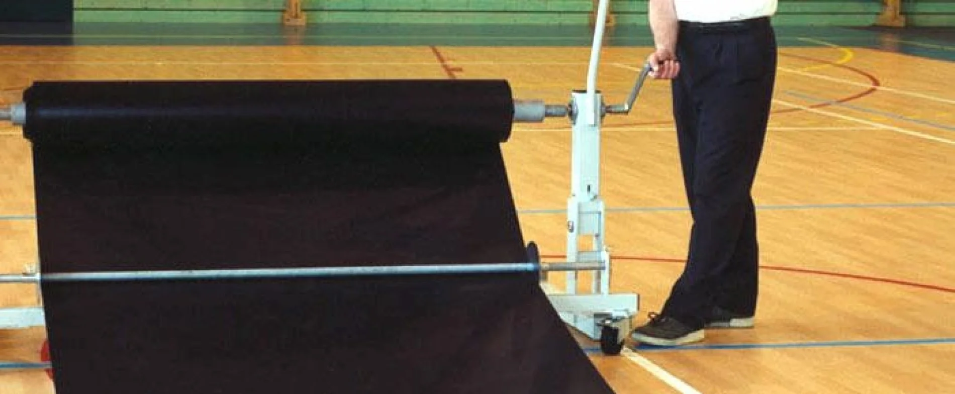 Taraflex Bateco protective layer being unrolled over a sports floor