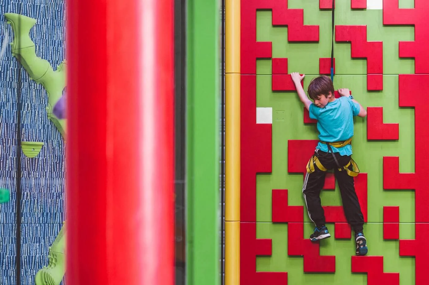 Child climbing a Clip n' Climb challenge wall on an auto belay