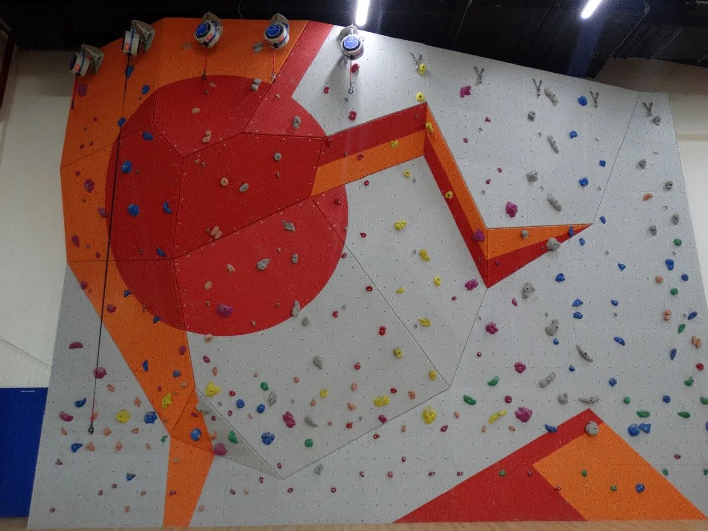 MozaiK wood climbing wall with geometric graphics and auto belays